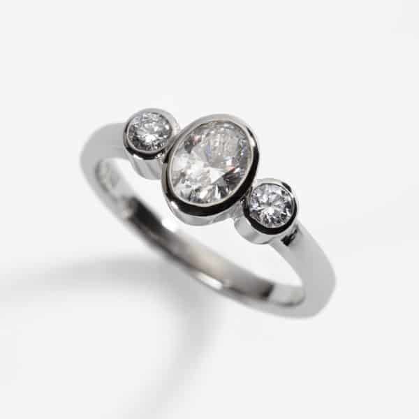 platinum three stone engagement ring, oval diamond 0.62ct, D, VS1, 2 x 0.10ct diamonds
