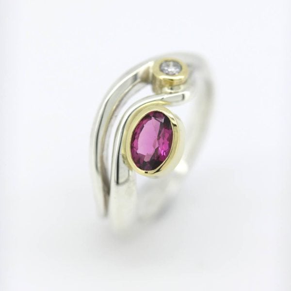 Silver wave ring with Pink oval tourmaline and 2.5mm diamond in 18ct yellow gold settings.