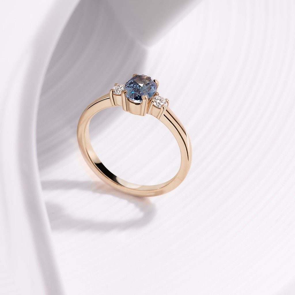 18ct yellow gold three stone claw set ring with 1.09ct oval, blue Gombe Sapphire and 2 x 2.8mm round brilliant cut diamonds, €3,900